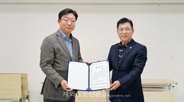 서만교 북경한국인회 회장 당선인(왼쪽)이 서기환 북경한국인회 선거관리위원장으로 부터 당선증을 받고 있다. [이나연 재외기자]