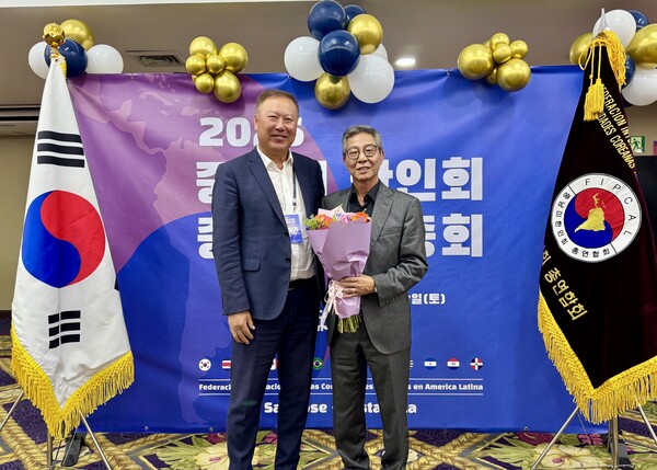 백창기 중남미 총연 회장이 이범구 신임회장에게 꽃다발을 전달하고 있다.[중남미 총연]