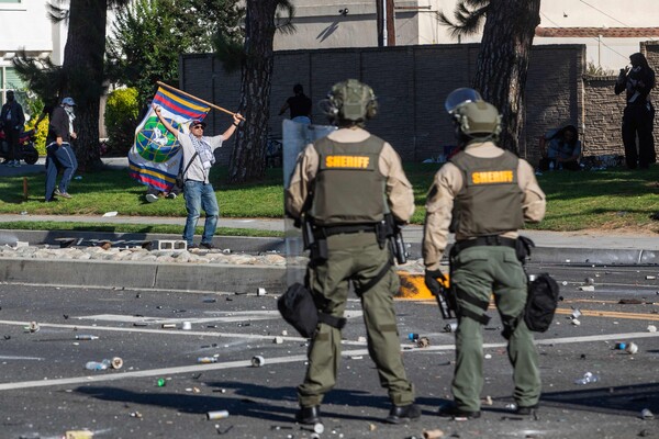 7일(현지시간) LA에서 이민 단속 반대 시위를 하는 모습과 이를 지켜보는 시위진압 요원들. [LA AFP=연합뉴스]