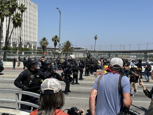 8일(현지시간) 미국 LA 도심의 연방 구금시설인 '메트로폴리탄 디텐션 센터' 앞 대로에서 경찰과 시위대가 대치하는 모습. [사진=연합뉴스]