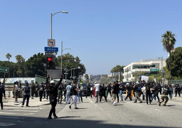 8일(현지시간) 미국 로스앤젤레스(LA) 도심의 연방 구금시설인 '메트로폴리탄 디텐션 센터'(Metropolitan Detention Center) 앞 대로에서 경찰과 시위대가 대치하고 있다. 시위대는 미 이민세관단속국(ICE)의 대대적인 불법 이민자 단속에 반발하는 시위를 사흘째 벌이고 있다.[연합뉴스]