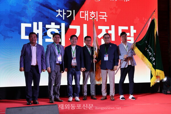 윤희 아총연·한상연 회장(왼쪽에서 두번째)이 2026 정기총회 개최국인 필리핀 한인회 및 한상연합회에 대회기를 전달한뒤 함께 기념촬영을 하고 있다. [황복희 기자]  