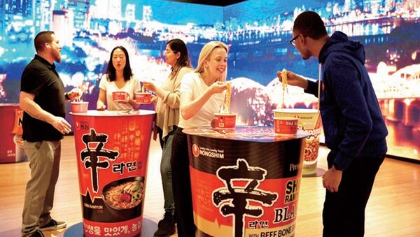 뉴욕한국문화원 1층에서 한강을 주제로 한 미디어월을 배경으로 현지 소비자들이 신라면을 먹고 있다. 