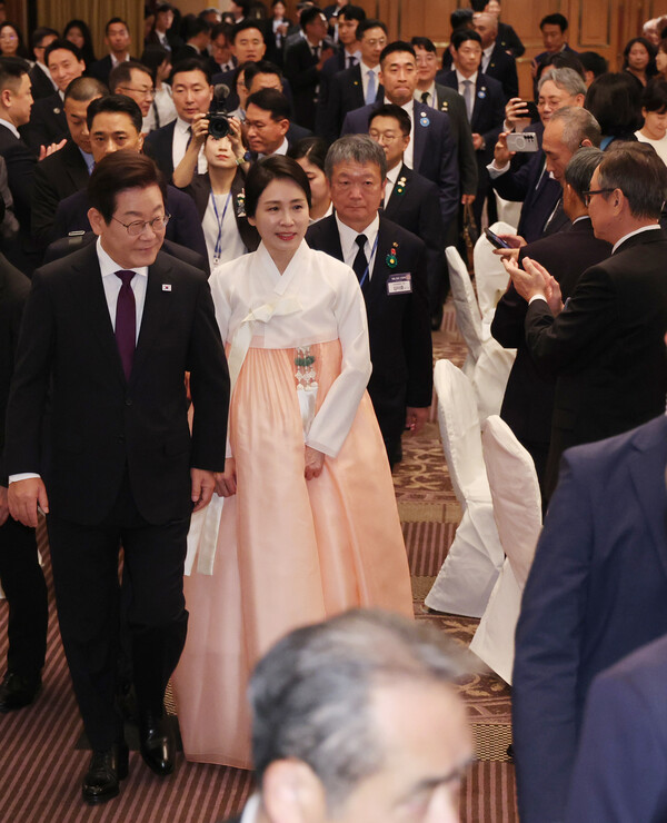 이재명 대통령과 김혜경 여사가 23일 일본 도쿄의 한 호텔에서 열린 재일동포 오찬 간담회에 입장하고 있다. 김 여사 뒤로 김이중 재일민단 단장이 들어오고 있다. 