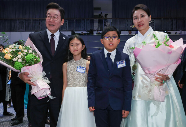이재명 대통령과 김혜경 여사가 22일(현지시간) 뉴욕의 한 호텔에서 열린 동포간담회에서 화동과 기념촬영을 하고 있다. [연합뉴스]