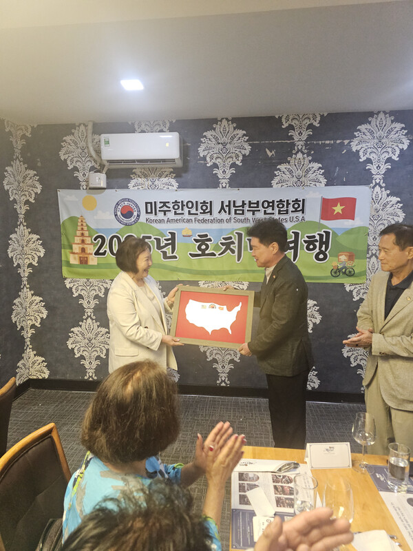 조규자 미 서남부연합회장(좌)이 윤영석 호치민 한-베가족협회장에게 장학금을 전달하면서 양 동포사회의 우정을 위해 특별히 미국에서 제작한 액자를 건네주고 있다.
