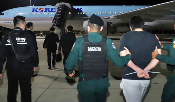 지난 10월 18일 자정(현지 시각), 프놈펜 떼쪼 국제공항에서 포승줄에 묶인 상태로 대한항공 특별 전세기를 타고 국내로 호송되기 위해 이동하는 한국인 온라인 범죄 가담자들. [크메르타임스]
