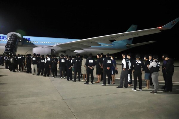지난 10월 19일 자정(현지시각) 한국인 온라인 범죄 가담자 65명이 대한항공 특별전세기편에 포승줄에 묶인 채 탑승하고 있다. [크메르 타임스]