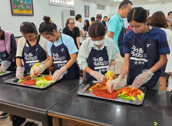 다문화가정 주부들과 현지 여성 주민들이 함께 김치를 만들고 있다. [한인회]
