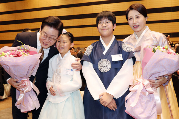 이재명 대통령과 김혜경 여사가 14일 일본 나라현의 한 호텔에서 열린 간사이 동포 간담회에서 화동과 기념촬영을 하고 있다. [연합뉴스]