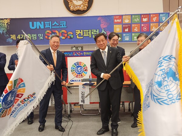 강태선 회장(사진 왼쪽)이 SDGs 깃발을, 김점배 회장이 UN피스코 단체기를 흔들고 있다.