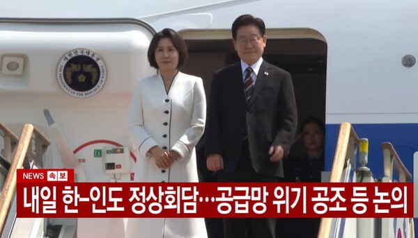 이재명 대통령이 19일 인도·베트남 5박6일 국빈 방문을 위해 부인 김혜경 여사와 함께 공군1호기에 탑승해 인사하고 있다. [YTN뉴스 캡처]  