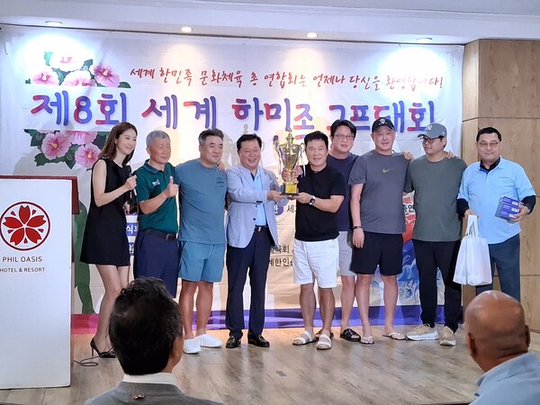 6월27일 필리핀 마닐라 알라방 필 오아시스 호텔에서 열린 '제8회 세계 한민족 골프대회' 시상식에서 말레이시아팀이 우승 트로피를 들어 올리며 기념촬영을 하고 있다. 이번 대회는 세계한민족문화체육총연합회(회장 윤만영)가 주최하고 세계한민족골프협회(회장 조철형)와 필리핀한인총연합회가 공동 주관했다. 2026 아시아한인회장대회 피날레 행사로, 재외동포 골프인들의 친목과 교류 증진을 위해 현지 파인힐스CC에서 개최됐다. 알라방 필 오아시스호텔은 윤만영 회장이 운영하는 곳으로 시상식에 이어 오찬이 진행됐다.